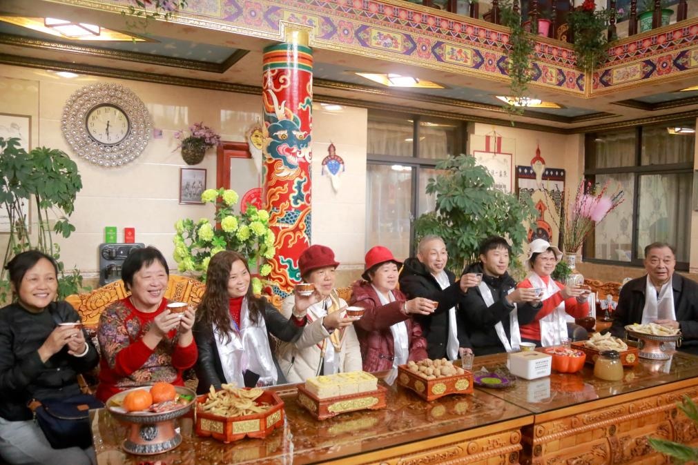 游客們?nèi)胱∶袼藓?，舉杯共飲酥油茶。新華社記者 邱星翔 攝