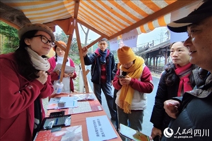 1月6日，“2024成都蒲江柑甜采摘節(jié)”上，記者見到了小萌（左一）和許多年輕人忙著做訪客接待、現(xiàn)場布置、票務核對、采摘服務等工作。人民網(wǎng)記者朱虹攝