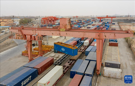 4月21日，二連浩特鐵路口岸龍門吊吊裝中歐班列集裝箱（無(wú)人機(jī)照片）。 新華社發(fā)（張海峰攝）