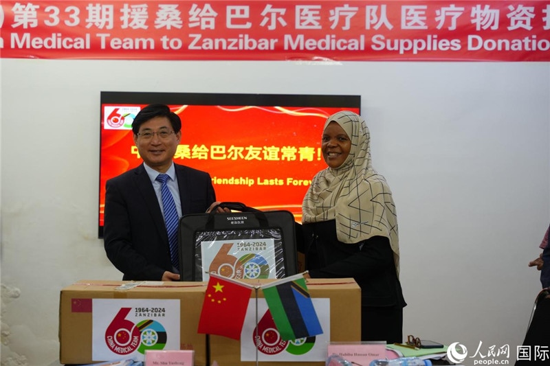 江蘇省蘇北人民醫(yī)院黨委書記束余聲捐贈物資與桑衛(wèi)生部首席秘書哈比巴。中國援桑醫(yī)療隊供圖
