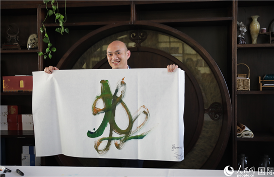 老撾駐華大使館三秘明君參加《五百筆·瀾湄合作》集體藝術(shù)創(chuàng)作。人民網(wǎng)王婧攝。