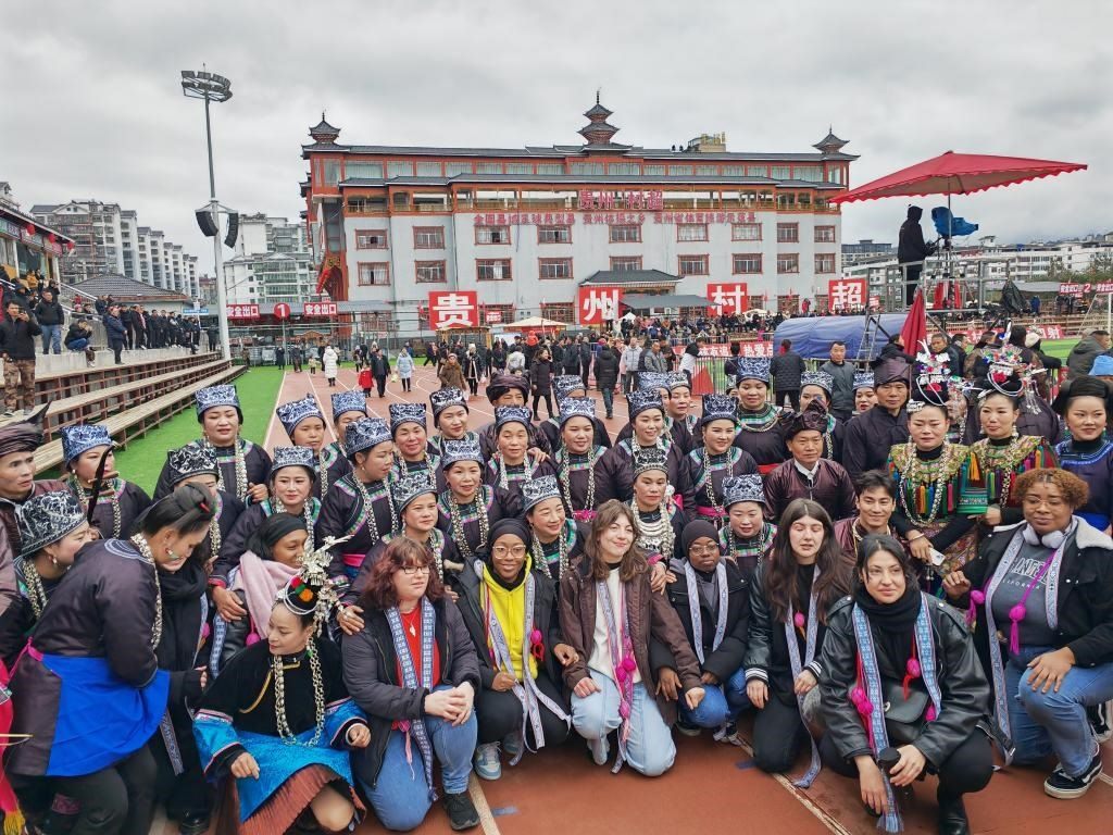 法國青年在“村超”賽場邊與參加表演的村民合影。新華社記者 羅羽 攝