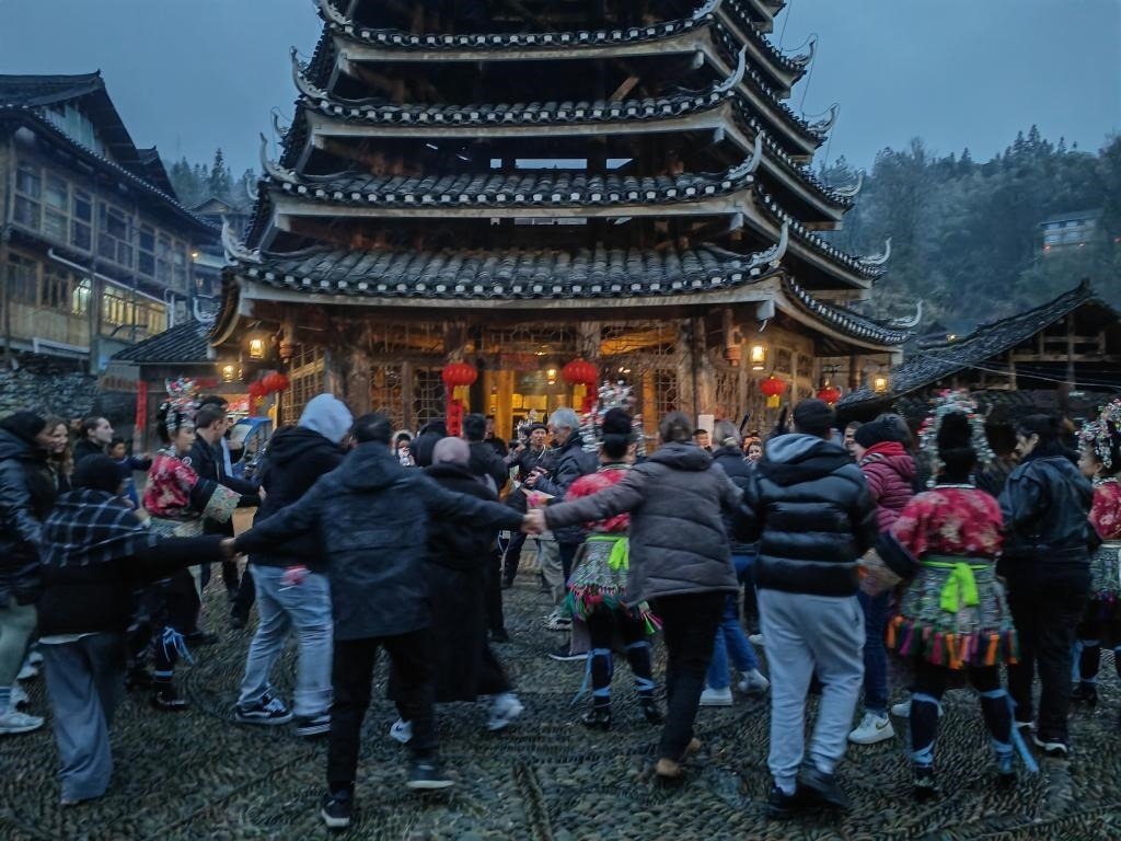 法國青年與當(dāng)?shù)卮迕駹渴痔?。新華社記者 羅羽 攝