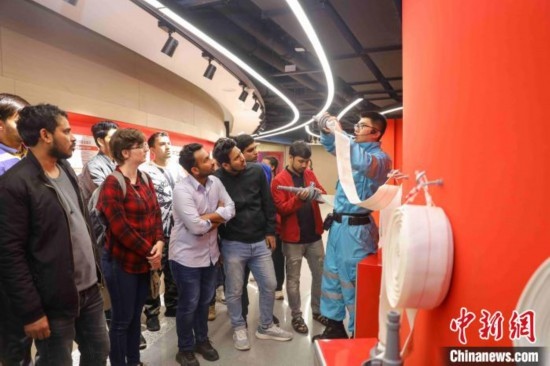 5月9日，工作人員指導(dǎo)留學(xué)生正確使用消防水帶。張鷹 攝