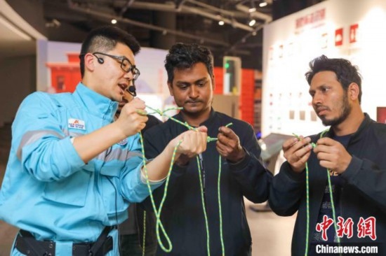 5月9日，工作人員指導(dǎo)留學(xué)生學(xué)習(xí)打繩結(jié)。張鷹 攝