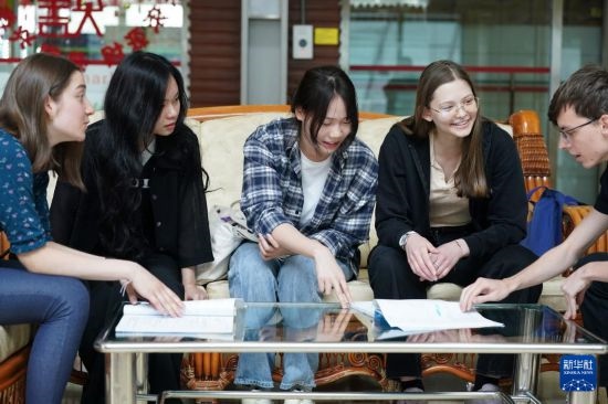 4月28日，宋智孝（右二）和胡靈月（左一）在北京首都師范大學(xué)校園內(nèi)與同學(xué)交流。新華社記者 彭子洋 攝