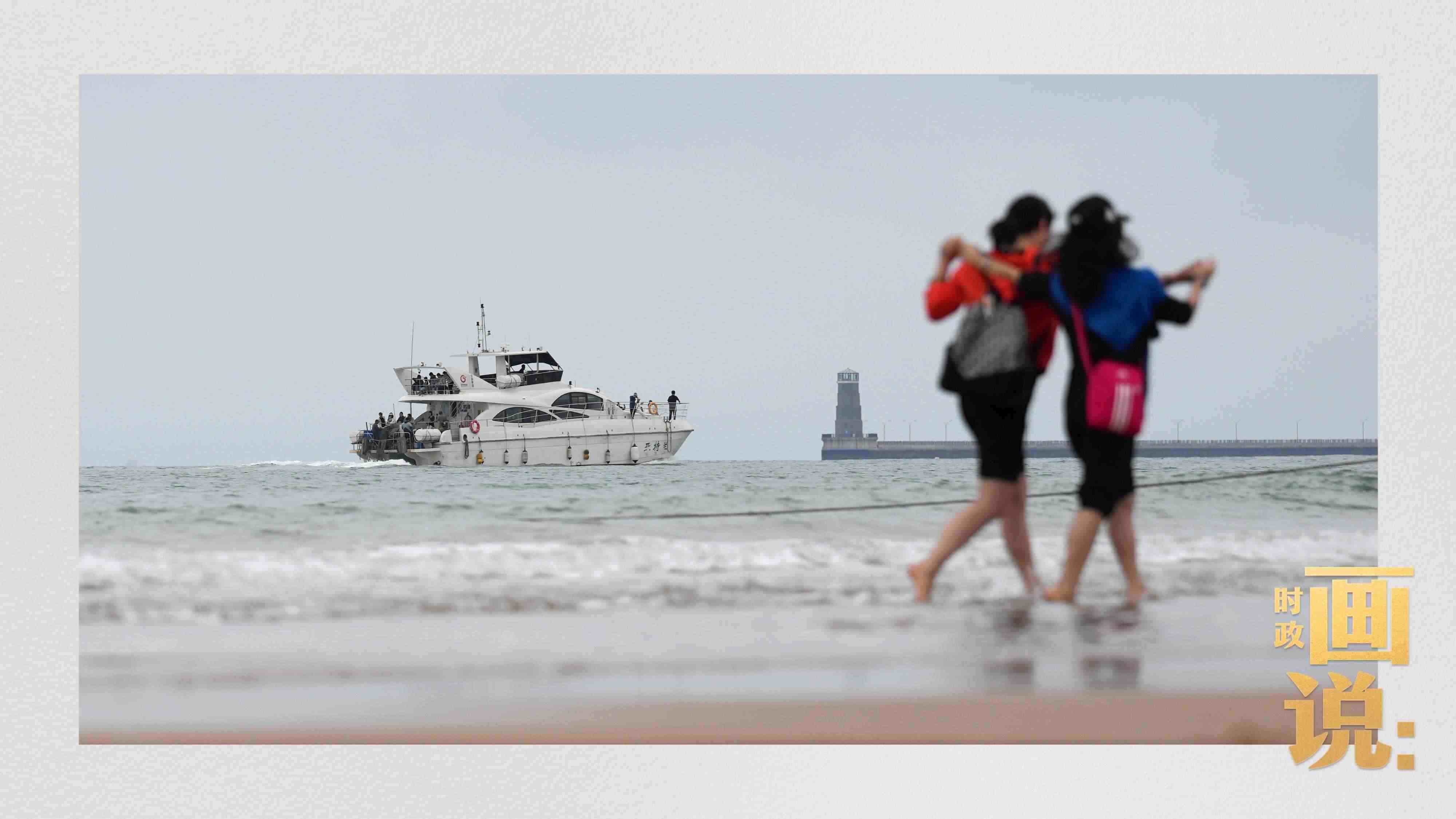 △日照陽光海岸綠道上的萬平口景區(qū)，一對游客在海浪中翩然起舞。