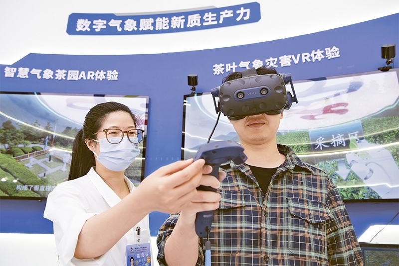 2024年5月23日，第七屆數(shù)字中國建設(shè)峰會現(xiàn)場體驗區(qū)在福州海峽國際會展中心向?qū)I(yè)觀眾開放。本次現(xiàn)場體驗區(qū)圍繞本屆峰會主題“釋放數(shù)據(jù)要素價值，發(fā)展新質(zhì)生產(chǎn)力”，設(shè)置“數(shù)字惠民”、“數(shù)字能力”、“數(shù)字基礎(chǔ)”、“數(shù)字生態(tài)”、“數(shù)字賦能”五大板塊。圖為一名觀眾（右）在數(shù)字氣象賦能新質(zhì)生產(chǎn)力展臺上進(jìn)行體驗。 新華社記者 魏培全/攝