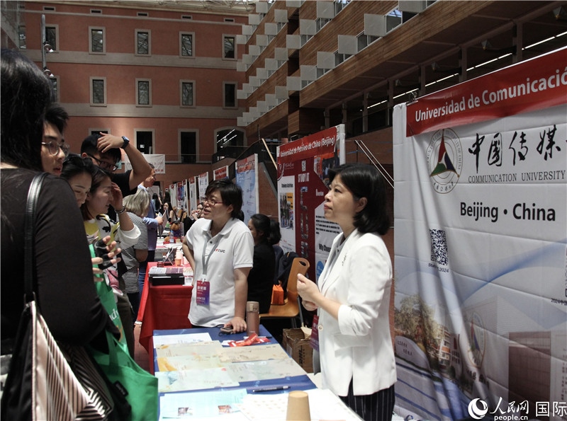 旅西華人華僑在展臺(tái)前咨詢。人民網(wǎng)記者 許海林?jǐn)z