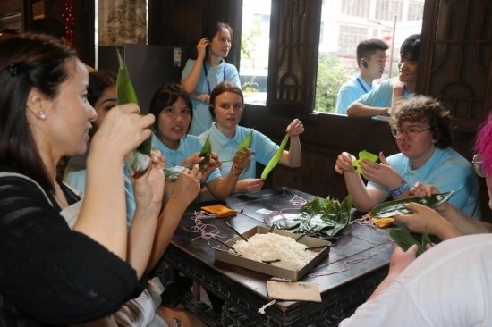 6月9日，美國青年代表在重慶永川松溉古鎮(zhèn)體驗包粽子。新華社記者 周思宇 攝