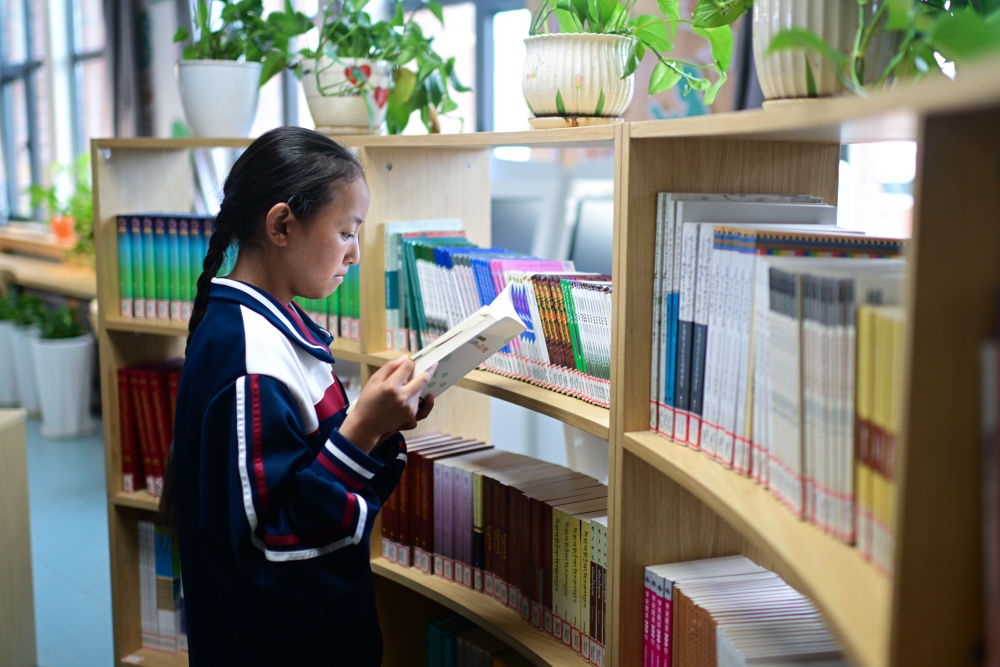 6月18日，果洛西寧民族中學(xué)學(xué)生尼東拉毛在圖書室看書。