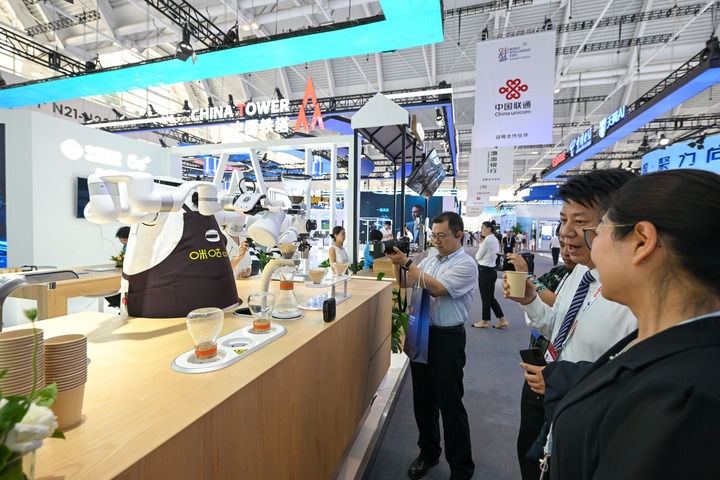 6月20日，與會者品嘗機器人沖調(diào)出的咖啡。新華社記者 孫凡越 攝