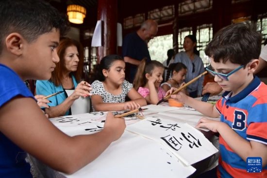 7月4日，在馬耳他桑塔露琪亞市的中國古典園林“靜園”，人們體驗中國書法。新華社發(fā)（喬納森·博格 攝）