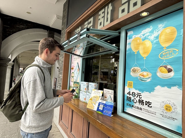 來自德國的留學生理查德在杭州西湖邊一家商鋪使用支付寶掃碼支付（2024年4月11日攝）。新華社發(fā)