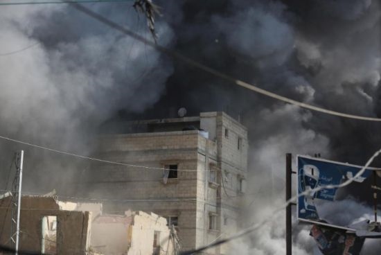 7月21日，在加沙地帶中部的努賽賴特難民營(yíng)，遭以軍空襲的建筑冒出滾滾濃煙。新華社發(fā)（馬爾萬(wàn)·達(dá)烏德攝）