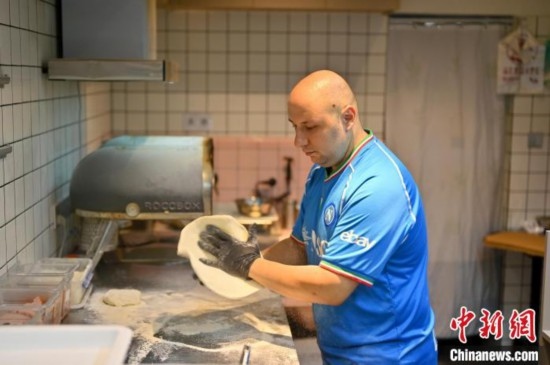 近日，韋榮耀在自家披薩小店內(nèi)忙活。俞靖 攝