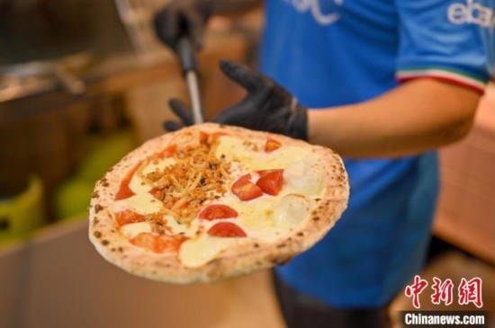 近日，韋榮耀展示他制作的“老友味”披薩。 俞靖 攝