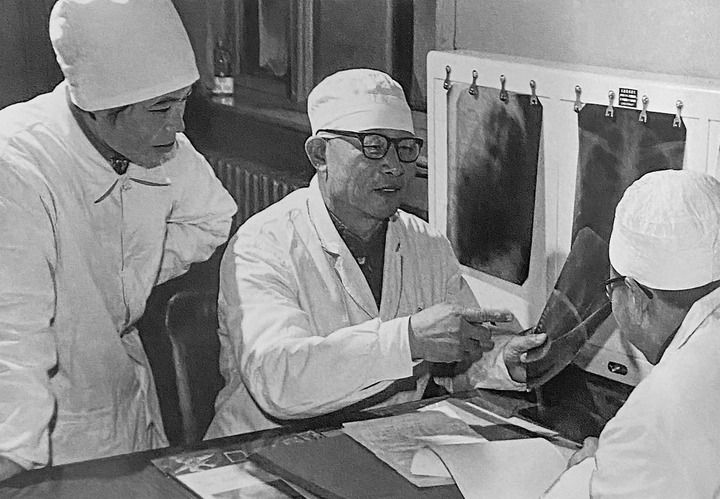 1980年1月16日，中日友好醫(yī)院首任院長辛育齡（中）在內(nèi)蒙古結(jié)核病院與胸外科醫(yī)師討論病例（翻拍照片）。 新華社發(fā)