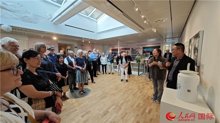 參展人、景德鎮(zhèn)陶瓷大學(xué)美術(shù)學(xué)院副院長(zhǎng)邵長(zhǎng)宗（右一）向來(lái)賓介紹參展作品。人民網(wǎng)記者 殷淼攝