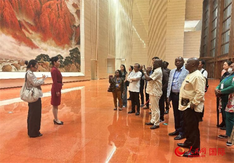 代表團在入口處聽取講解。人民網(wǎng) 曹欣悅攝