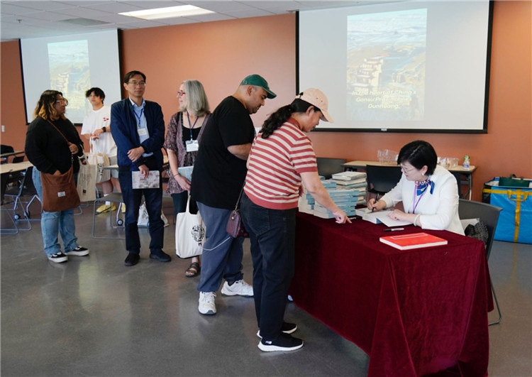 作者顧春芳在活動現(xiàn)場簽名贈書。羅先勇攝