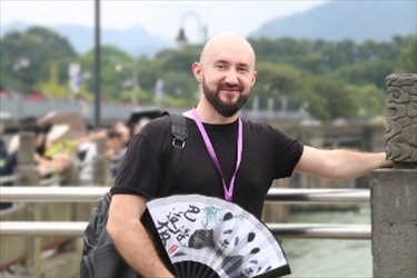 俄羅斯塔斯社執(zhí)行編輯葉夫根尼·扎多羅日內(nèi)在都江堰魚嘴拍照留念。（李佩藺 攝）