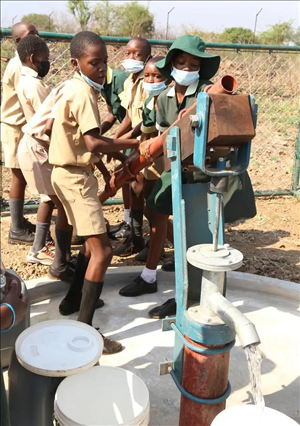 △2021年11月，在津巴布韋南馬塔貝萊蘭省省會關達的塞農(nóng)多小學，學生從中國援建水井里打水。