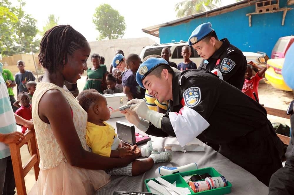 2017年12月28日，在利比里亞蒙羅維亞，中國(guó)維和警察防暴隊(duì)醫(yī)療人員為兒童做口腔檢查。