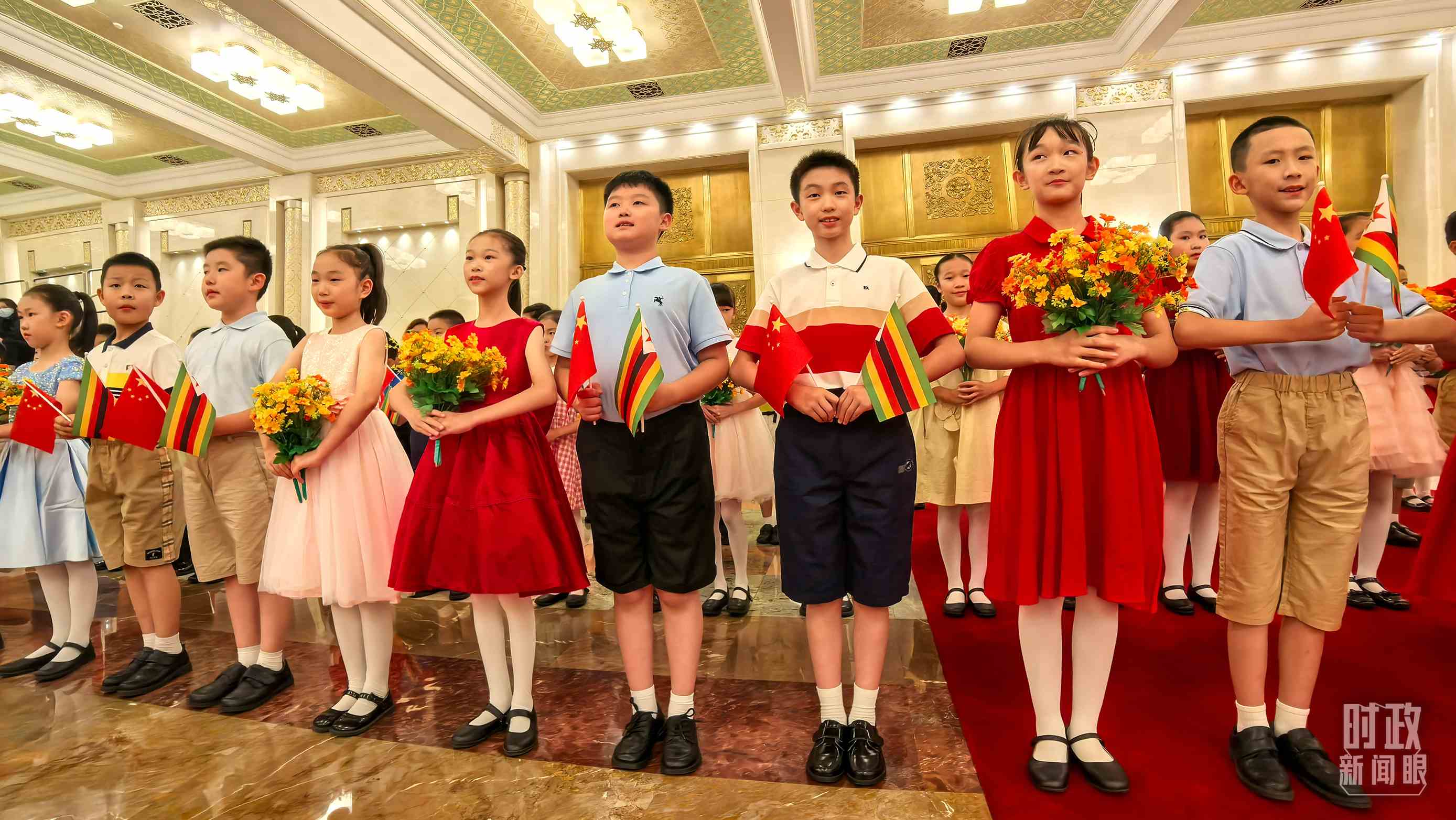 △現(xiàn)場歡迎津巴布韋總統(tǒng)訪華的青少年。（總臺央視記者鐘銳拍攝）