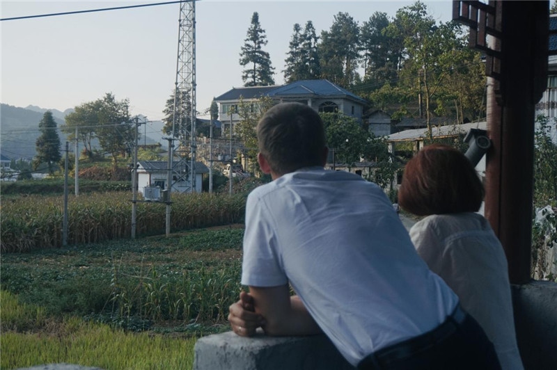 望得見山，看得見水，記得住鄉(xiāng)愁。每個人心中都有一個屬于自己的“花茂村”，在這方心田，走遍千山萬水，鄉(xiāng)音未改鬢毛衰。吉爾吉斯斯坦《比什凱克晚報》第一副總編輯妮娜·尼奇博洛娃與《中國與俄羅斯》雜志社社長奧列格·別列日內赫攝在花茂村民居屋檐下并肩佇立，眺望山水，尋覓鄉(xiāng)愁。（李光裕攝）