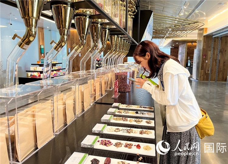 4. 代表團(tuán)團(tuán)員對(duì)新中式茶飲的食材充滿興趣。（人民網(wǎng)記者陳思 攝）