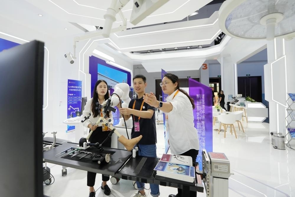 9月11日，一位媒體記者（中）在2024年服貿(mào)會國家會議中心會場體驗北京納通科技集團(tuán)有限公司的膝關(guān)節(jié)置換手術(shù)機器人。新華社記者鞠煥宗 攝