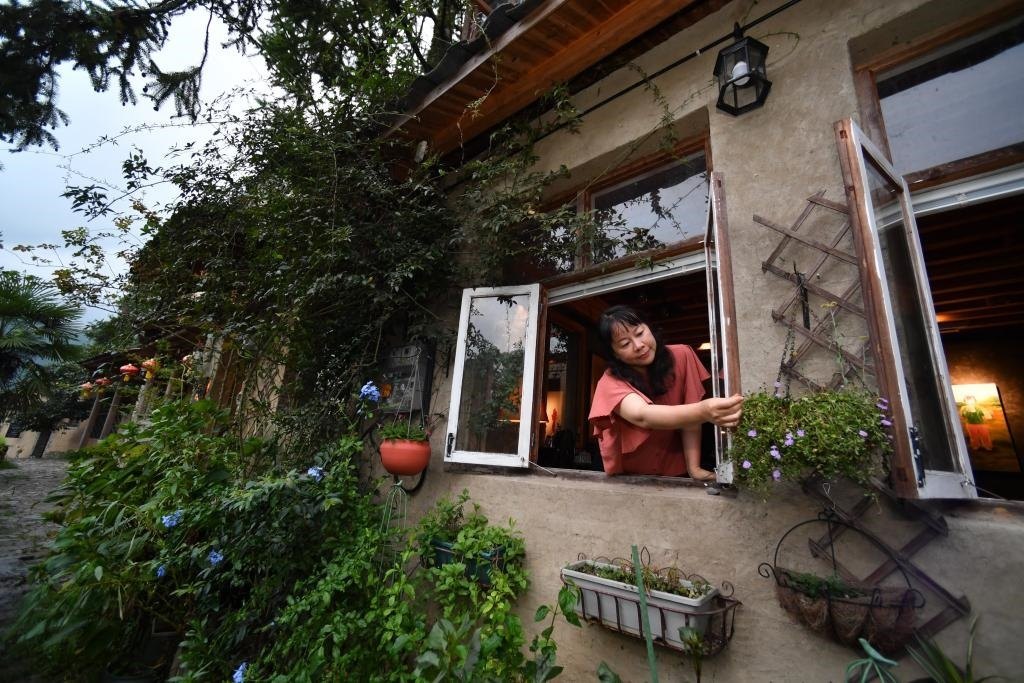 8月29日，在福建省屏南縣熙嶺鄉(xiāng)，龍?zhí)洞濉靶麓迕瘛泵泛暝诖蚶碜约航洜I的民宿外墻裝飾花盆。新華社記者姜克紅 攝