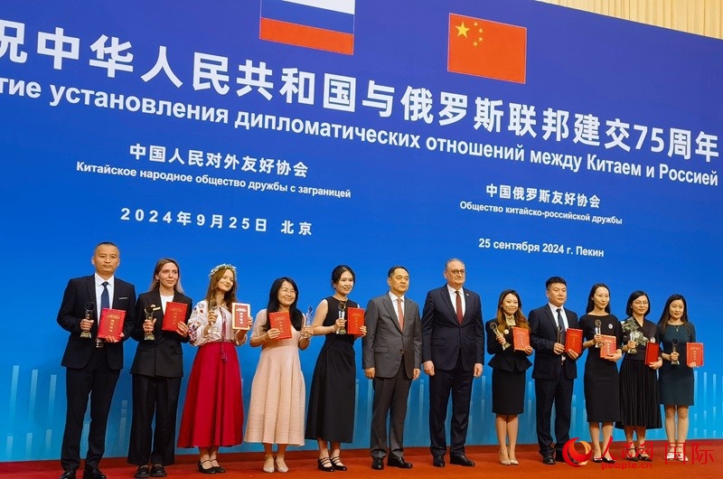 楊萬(wàn)明會(huì)長(zhǎng)和莫爾古洛夫大使為10位中俄青年友好微視頻創(chuàng)意大賽獲獎(jiǎng)代表頒獎(jiǎng)。人民網(wǎng)記者 李明琪攝