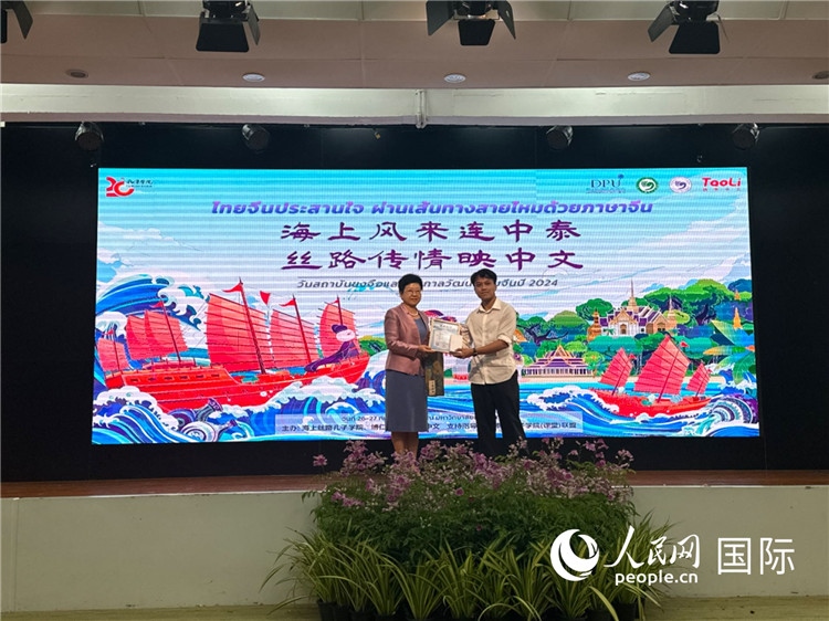 中國(guó)駐泰國(guó)大使館一等秘書王歡（左）為一等獎(jiǎng)獲獎(jiǎng)?wù)哳C獎(jiǎng)