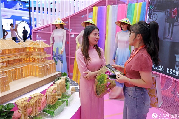 參觀者在東博會越南展區(qū)同工作人員咨詢交談。人民網(wǎng)記者 趙益普攝