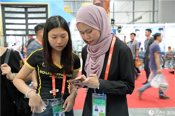 東博會現(xiàn)場，馬來西亞展商在同中方工作人員交談。人民網(wǎng)記者 趙益普攝