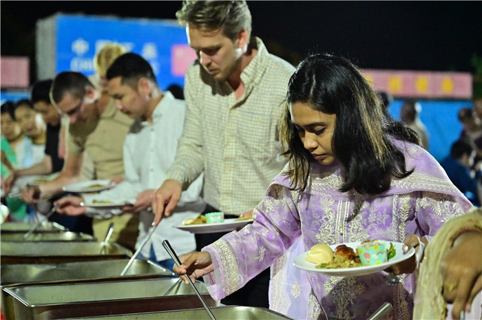 外國(guó)友人品嘗中國(guó)美食。馬騫攝