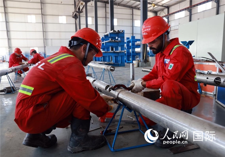 中伊員工共同在檢修鉆井設備。人民網記者管克江攝