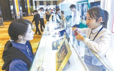 在北京麗澤商務(wù)區(qū)，工作人員（右一）介紹數(shù)字人民幣SIM卡硬錢包。新京報記者 陶冉攝