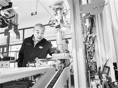 郭海青在檢查車床加工設(shè)備。 受訪者供圖