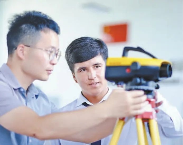 在塔吉克斯坦首都杜尚別的魯班工坊，來(lái)自天津城市建設(shè)管理職業(yè)技術(shù)學(xué)院的老師（左）為當(dāng)?shù)貙W(xué)生提供指導(dǎo)。新華社記者 鄭開(kāi)君 攝