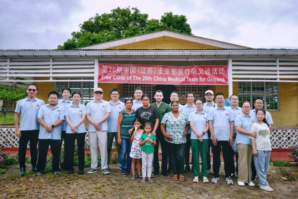 第20期中國(guó)（江蘇）援圭亞那醫(yī)療隊(duì)在圭偏遠(yuǎn)的林登高速社區(qū)開展義診后，與部分當(dāng)?shù)鼐用窈嫌啊?中國(guó)援圭醫(yī)療隊(duì)供圖