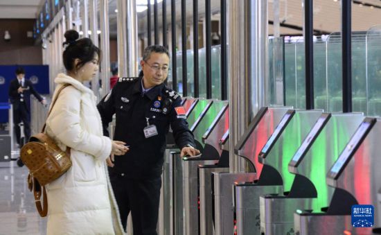 1月2日，大興機(jī)場邊檢站警察指導(dǎo)旅客使用自助出境設(shè)備。新華社記者 李欣 攝