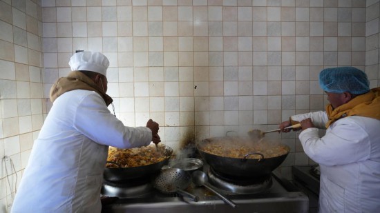 1月14日，服務(wù)隊(duì)的兩名廚師正在為村民們做午飯。新華社記者 邱星翔 攝