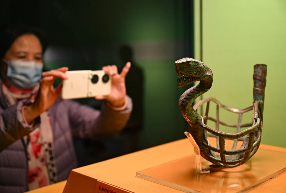 1月14日，觀眾在上海博物館蛇年迎春展拍攝展品蛇綱網(wǎng)狀銅器。新華社發(fā)（陳浩明攝）