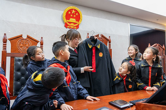 圖②：干警向同學(xué)們介紹法袍。