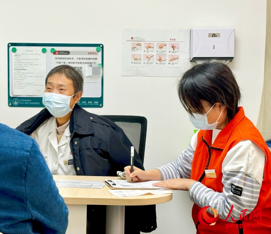 秦苑（中）接診患者。人民網(wǎng)記者 金慧慧攝