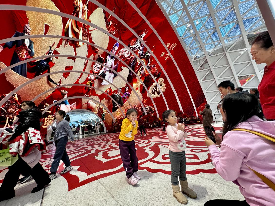 乙巳蛇年春節(jié)期間，影迷在《哪吒之魔童鬧?！肪薹?bào)前拍照打卡。