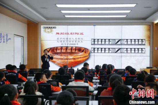 圖為學(xué)生在“國寶音樂會(huì)”社教課中了解舞蹈紋彩陶盆。中新社記者 馬銘言 攝